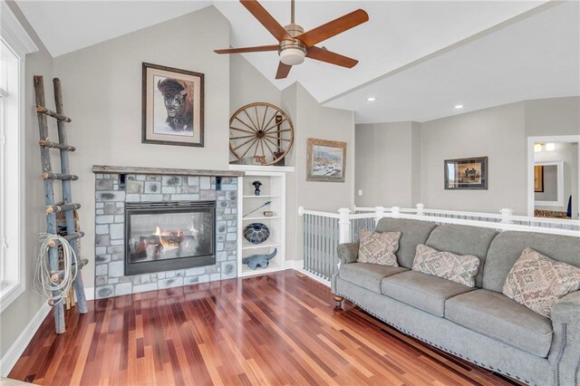 living room with lofted ceiling, a fireplace, baseboards, and wood finished floors