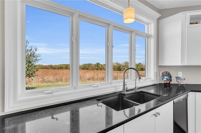 kitchen featuring a wealth of natural light, pendant lighting, white cabinetry, and a sink