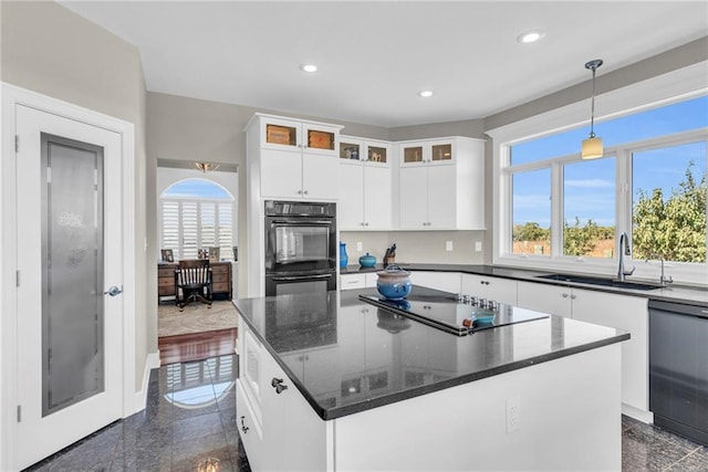 kitchen featuring a center island, a sink, black appliances, and recessed lighting