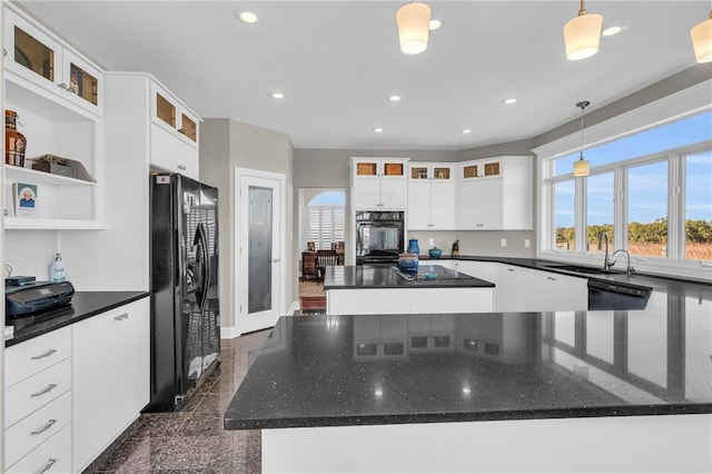 kitchen with a center island, recessed lighting, granite finish floor, a healthy amount of sunlight, and black appliances