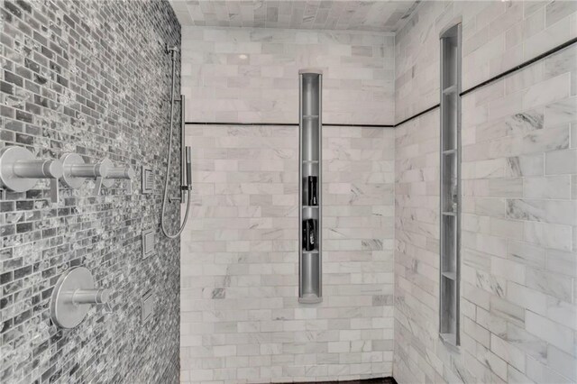 interior details featuring a tile shower