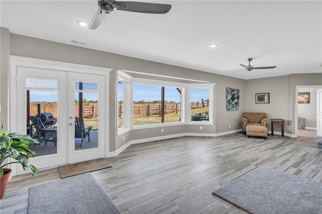 sitting room featuring wood finished floors, a ceiling fan, visible vents, baseboards, and french doors