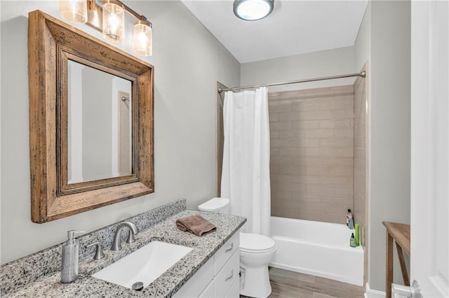 bathroom with toilet, wood finished floors, shower / bath combination with curtain, and vanity