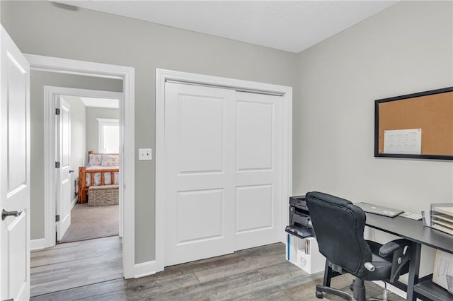 home office featuring baseboards and wood finished floors