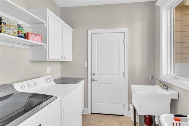 washroom with cabinet space, a healthy amount of sunlight, separate washer and dryer, a sink, and light tile patterned flooring