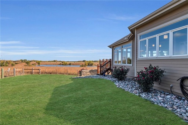 view of yard featuring a water view and fence