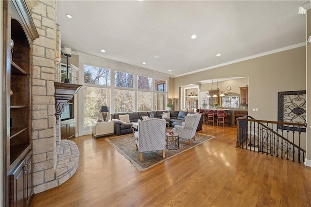 living room featuring recessed lighting, a chandelier, wood finished floors, and ornamental molding