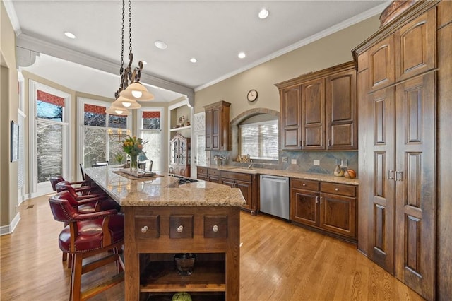 kitchen featuring light wood finished floors, an island with sink, light stone counters, stainless steel dishwasher, and open shelves