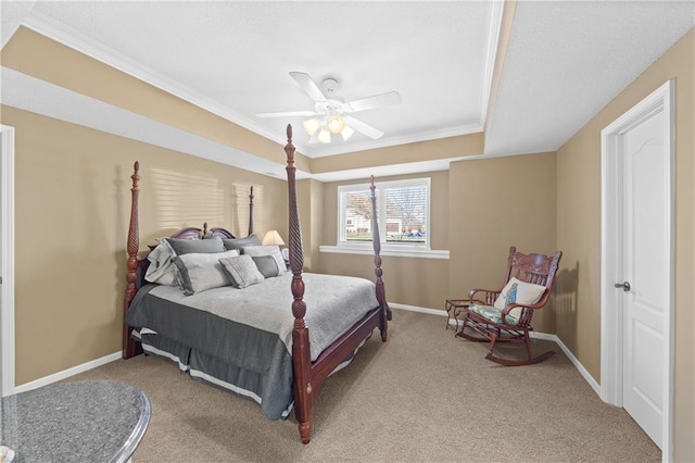 bedroom with crown molding, ceiling fan, baseboards, carpet, and a raised ceiling