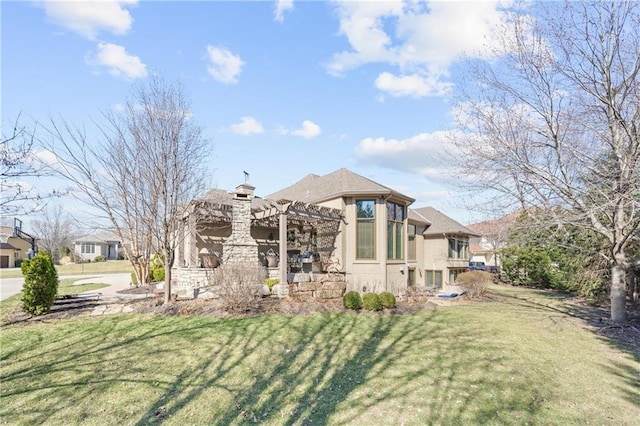 back of property with stucco siding, a lawn, and a pergola