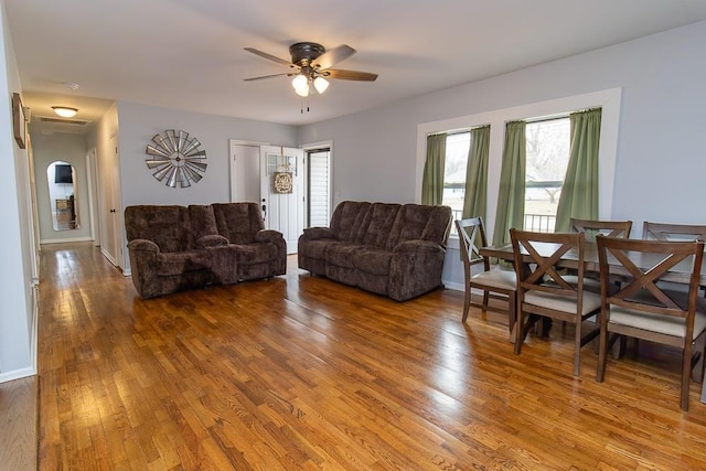 living room with ceiling fan, wood finished floors, and baseboards