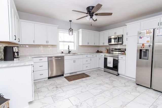 kitchen with marble finish floor, appliances with stainless steel finishes, white cabinets, and a sink