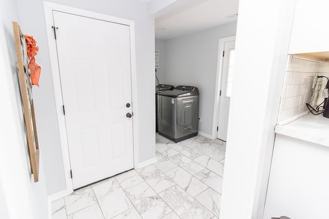 laundry room featuring washing machine and dryer, marble finish floor, baseboards, and laundry area