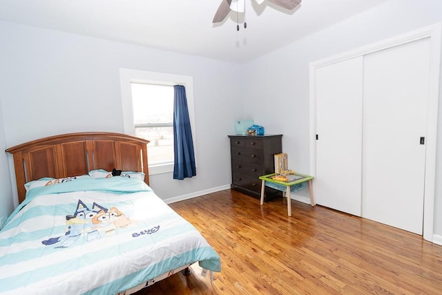 bedroom with light wood-style flooring, baseboards, ceiling fan, and a closet