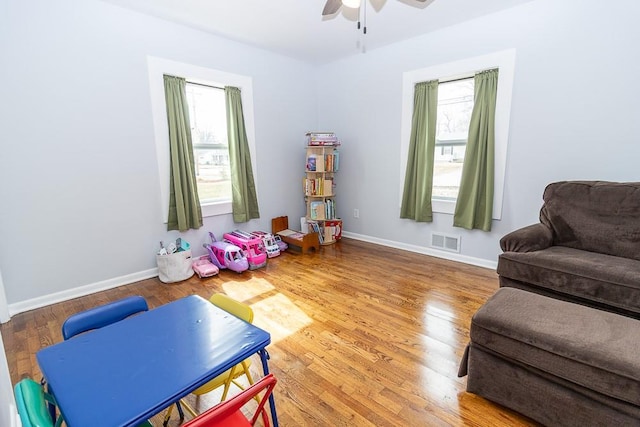 playroom with baseboards, visible vents, a wealth of natural light, and wood finished floors