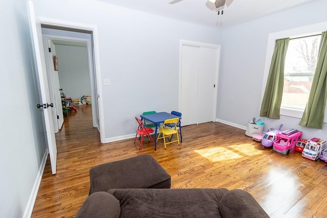 playroom featuring ceiling fan, baseboards, and wood finished floors