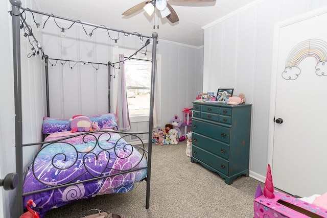 carpeted bedroom featuring a ceiling fan and crown molding