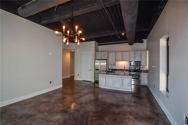 kitchen with stainless steel appliances, dark countertops, backsplash, and baseboards