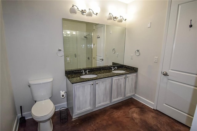 bathroom with a sink, a shower stall, toilet, and baseboards