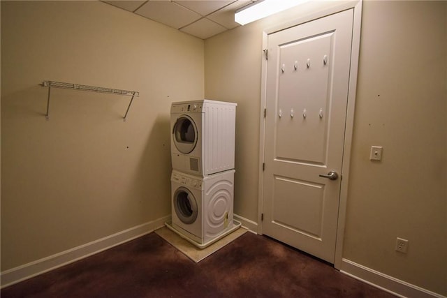 washroom with laundry area, stacked washer and dryer, and baseboards