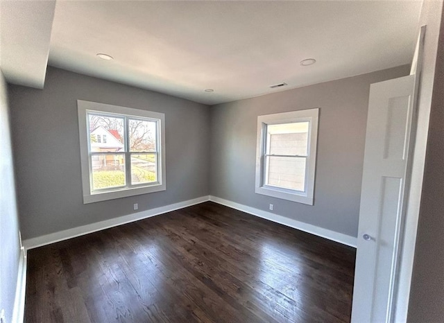 spare room with visible vents, baseboards, dark wood-type flooring, and recessed lighting