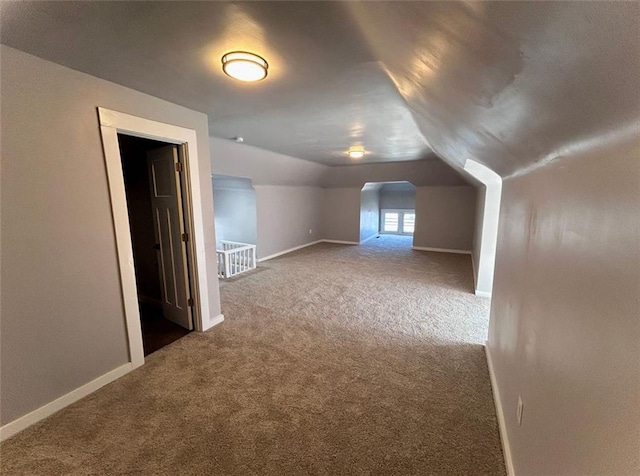 additional living space with lofted ceiling, carpet, and baseboards