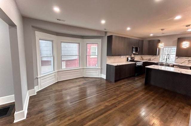 kitchen featuring recessed lighting, dark wood-style flooring, a sink, dark brown cabinets, and appliances with stainless steel finishes