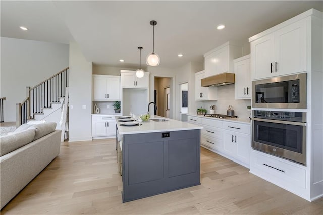 12455 N Arbor Way, Platte City, MO 64079 - kitchen featuring appliances with stainless steel finishes, open floor plan, backsplash, white cabinets, and recessed lighting
