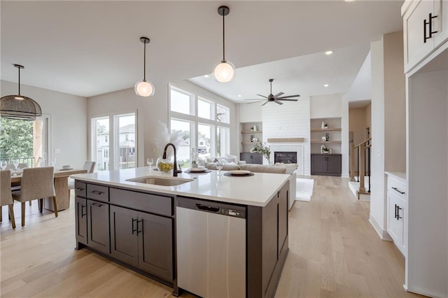 12455 N Arbor Way, Platte City, MO 64079 - kitchen with stainless steel dishwasher, ceiling fan, light countertops, a large fireplace, and light wood-style floors