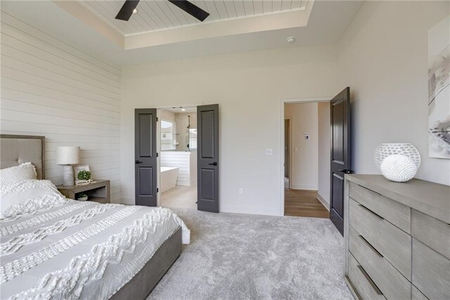 12455 N Arbor Way, Platte City, MO 64079 - bedroom with a tray ceiling, light carpet, ensuite bathroom, and a ceiling fan