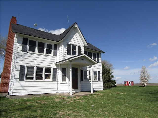 view of front of home with a front yard and a chimney