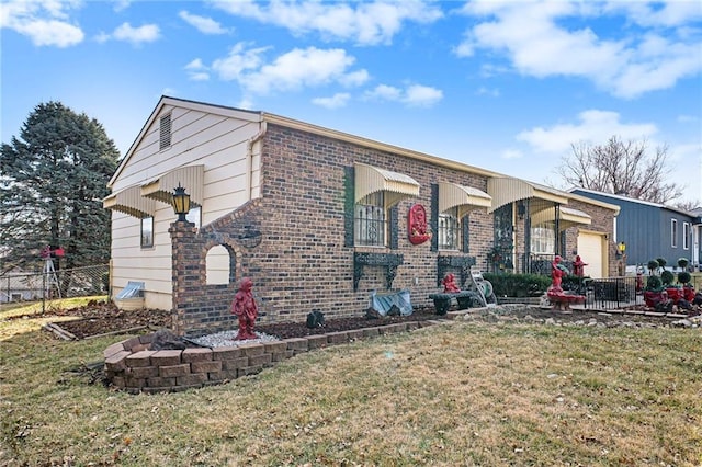 view of front of home with an attached garage, fence, a front lawn, and brick siding