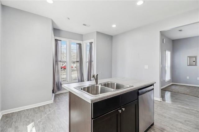 kitchen with a sink, visible vents, baseboards, dishwasher, and an island with sink