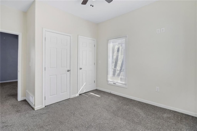 unfurnished bedroom with carpet floors, a ceiling fan, visible vents, and baseboards