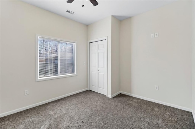 unfurnished bedroom with baseboards, visible vents, a ceiling fan, carpet flooring, and a closet