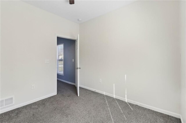 empty room featuring carpet floors, baseboards, and visible vents