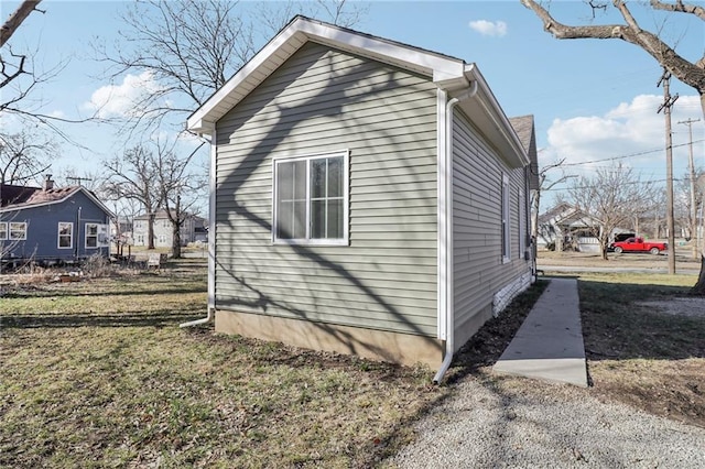 view of side of home with a yard