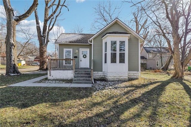 bungalow-style home featuring a shingled roof and a front lawn