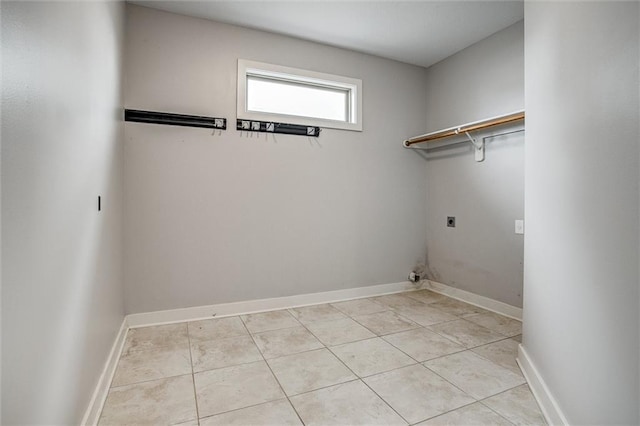 clothes washing area with laundry area, light tile patterned flooring, baseboards, and electric dryer hookup