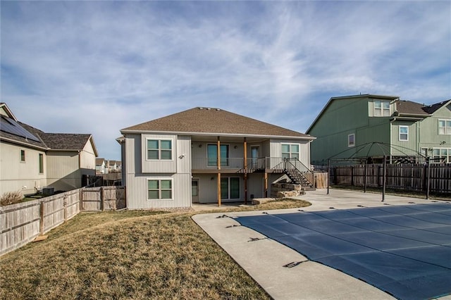 back of property featuring a fenced backyard, stairway, a residential view, a yard, and a patio area