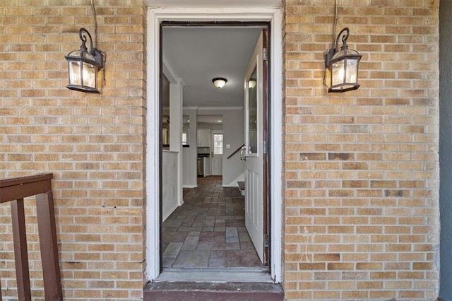 doorway to property featuring brick siding