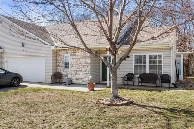 view of front of property with a garage, stone siding, a shingled roof, and a front lawn