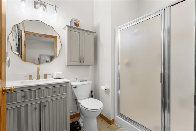 full bathroom with toilet, a stall shower, baseboards, and vanity