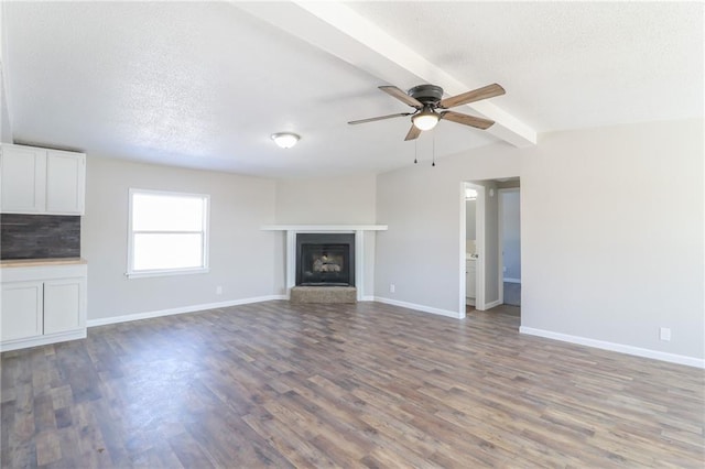 unfurnished living room with a fireplace with raised hearth, wood finished floors, and baseboards