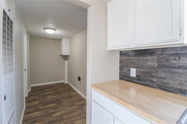 kitchen with baseboards, white cabinets, a heating unit, dark wood-style floors, and butcher block counters