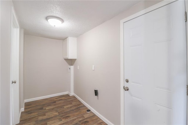 washroom featuring dark wood-style floors, cabinet space, a textured ceiling, and baseboards