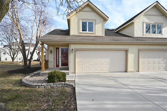 view of front facade with driveway, roof with shingles, an attached garage, and stucco siding