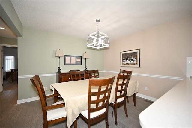 dining space with a chandelier, baseboards, and wood finished floors