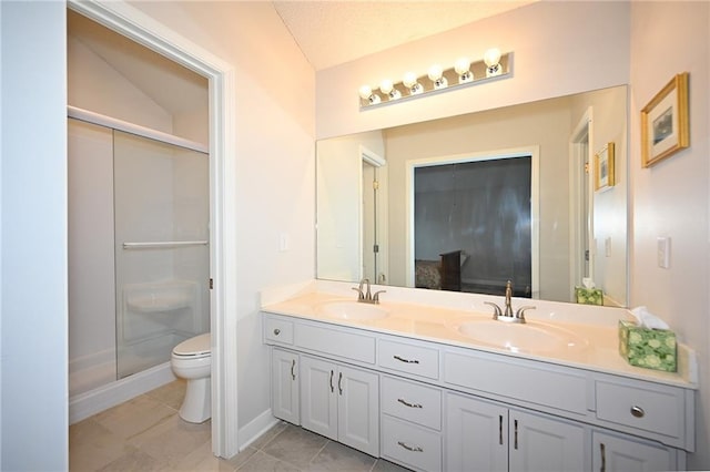 full bath with toilet, a shower stall, double vanity, and a sink