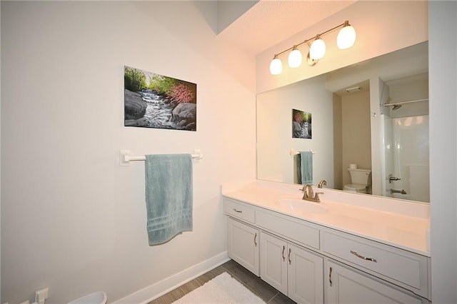 full bathroom with baseboards, a shower, toilet, wood finished floors, and vanity